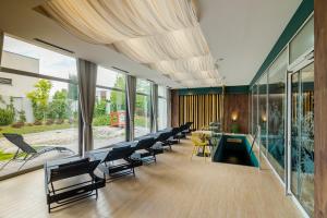 a room with chairs and a pool in a building at Hotel Bażantowo Sport in Katowice