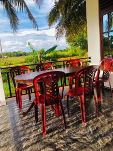 a table and chairs with a view of a field at Lumora Resort in Horuwila +15 photos