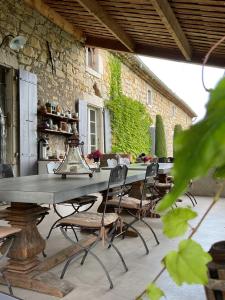 an outdoor patio with a long table and chairs at Chambres d'hôtes du Domaine de la Manse in Villeneuve-de-Berg
