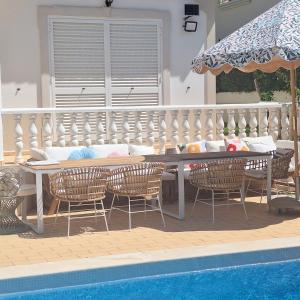 a patio with a table and chairs next to a pool at Santos Villa in Quinta do Lago in Quinta do Lago