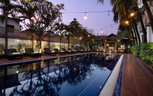 a swimming pool with lounge chairs next to a building at Harmony Indochine d'Angkor in Siem Reap
