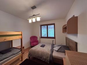 a bedroom with a bunk bed and a red chair at Apartmán Donovaly 90 in Donovaly