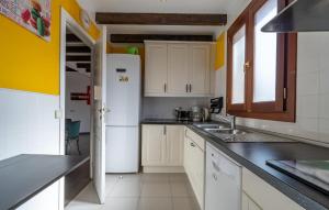a kitchen with white cabinets and a white refrigerator at Duplex Can Roses in Moscari +28 photos