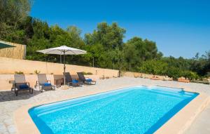 a swimming pool with chairs and an umbrella at Sa Finqueta in Manacor