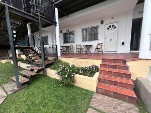 a house with a staircase and a porch with chairs at Canoas Apart in Colón