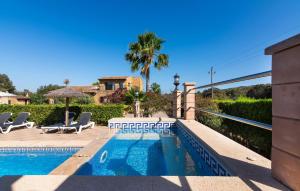 a swimming pool with chairs and a table next to a house at Na Peixet in Artá +34 photos