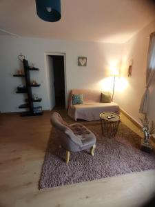 a living room with a couch and a chair at appartement dans maison de village in Pinet