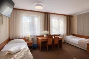 a hotel room with two beds and a desk at Załęże in Katowice