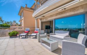 a patio with chairs and tables and a large window at Bohemi in Son Serra de Marina