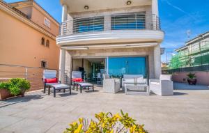 a patio with chairs and tables in front of a building at Bohemi in Son Serra de Marina