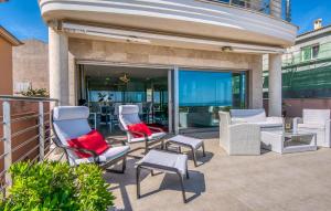a patio with chairs and tables and glass doors at Bohemi in Son Serra de Marina