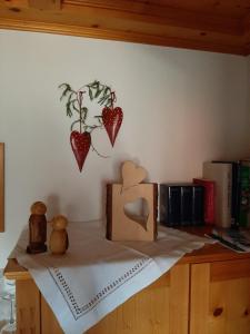 a shelf with hearts on a wall with books at Gästehaus Reichart in Scheidegg