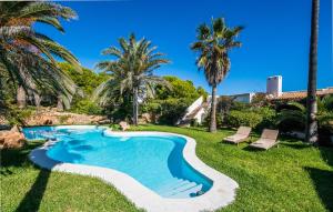 a swimming pool in a yard with palm trees at Can Roca De Cala D'or in Cala d´Or