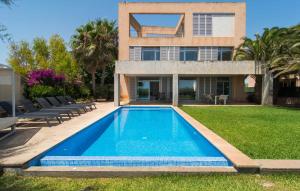 a house with a swimming pool in front of a house at Port Nou in Cala Bona