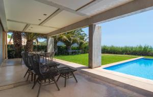 a patio with a table and chairs next to a swimming pool at Port Nou in Cala Bona +34 photos