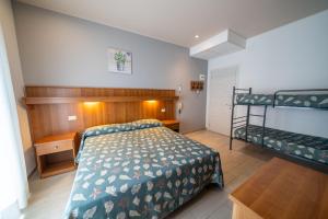a bedroom with a bed and a bunk bed at Hotel Jesolo Sand in Lido di Jesolo