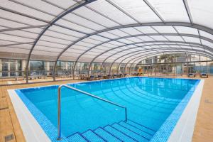 a large swimming pool with a glass ceiling at Jupiter Algarve Hotel - Beach & Spa in Portimão +64 photos