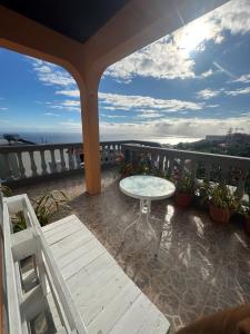a balcony with a table and a view of the ocean at Casa Mary Bela's in Ponta do Sol
