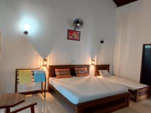 a bedroom with a bed with two pillows at Lagoonvilla hotel in Ambalangoda
