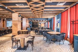 a restaurant with wooden tables and chairs and red curtains at New Gudauri Studio N207 in Suites! in Gudauri