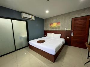 a bedroom with a large bed with white sheets at Easy Loft Hostel in Phuket