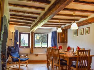 a dining room with a wooden table and chairs at Church House in Ulpha
