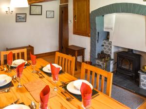 a wooden dining table with chairs and a fireplace at Church House in Ulpha