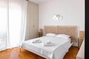 a bedroom with a white bed with two towels on it at Eca Apartments Atmabnb33 in Thessaloniki