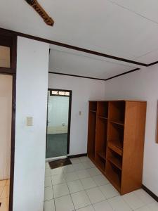 a room with white walls and a wooden cabinet at Hotel Pandu Lakeside Tuktuk in Tuktuk Siadong +16 photos