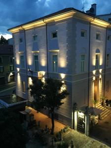 Un grand bâtiment blanc avec des lumières sur lui dans l'établissement Hotel Europa Varese, à Varèse