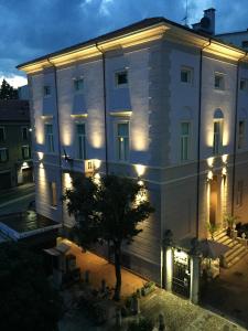 un grande edificio bianco con luci sopra di Hotel Europa Varese a Varese
