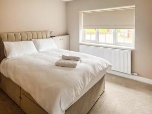 a bedroom with a large bed with two towels on it at Cleveland View Cottage in North Cowton