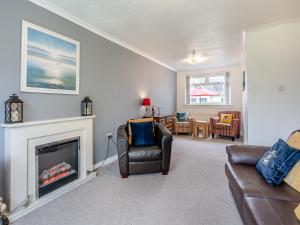 a living room with a fireplace and a couch at The Mulberry in Lamlash