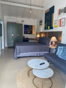 a bedroom with a bed and a couch and a table at Casa Mediterrânea Geribá in Búzios