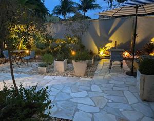 a patio with a table and chairs and an umbrella at Casa Mediterrânea Geribá in Búzios