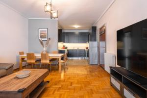 a living room with a dining room table and a kitchen at Eca Apartments Atmabnb33 in Thessaloniki