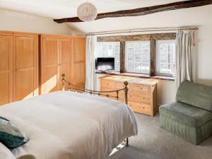 a bedroom with a bed and a chair and a window at Wellhead Cottage in Haworth +12 photos
