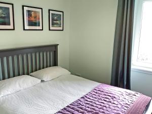 a bedroom with a bed with a purple blanket at Seasgair in Dingwall +3 photos