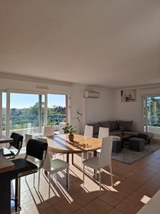 a living room with a wooden table and chairs at Appartement Riposa in Fréjus