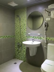 嘉義市的住宿－萬泰大飯店，一间带水槽、淋浴和镜子的浴室
