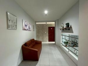 a living room with a brown couch and a red door at Easy Loft Hostel in Phuket