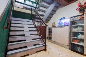 a staircase in a room with a refrigerator at RedDoorz Syariah near Pasar Pagi Samarinda in Samarinda