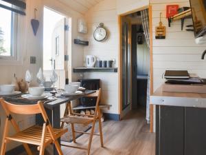 a kitchen with a table and chairs in a tiny house at Shepherds Hut - Uk50043 in Chipping