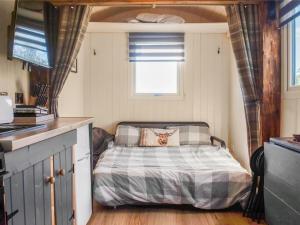 a bed in a small room with a window at Shepherds Hut - Uk50043 in Chipping