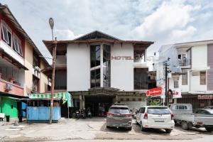a street with cars parked in front of a building at RedDoorz Syariah near Pasar Pagi Samarinda in Samarinda