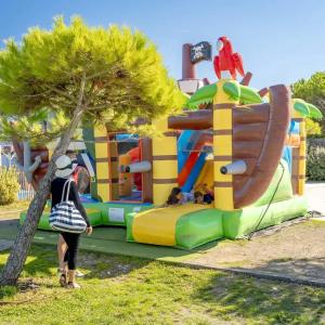 a woman standing in front of a inflatable playground at Camping A la Corniche - Maeva in Angoulins-sur-Mer