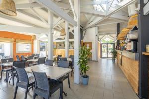 a dining room with tables and chairs in a restaurant at Camping A la Corniche - Maeva in Angoulins-sur-Mer