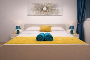 a bedroom with a bed with two blue towels on it at Comfortable ! Stylish ! Fully Air Conditioned ! in Sannat