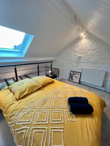 a large yellow bed in a room with a window at L'escale Barbieux in Croix