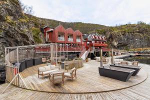 a wooden deck with chairs and tables on a boat at Kuringen Brygge Hotel and Restaurant in Refsnes